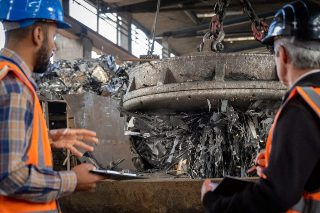 Men looking at recycling magnet in a warehouse by Okon Recycling